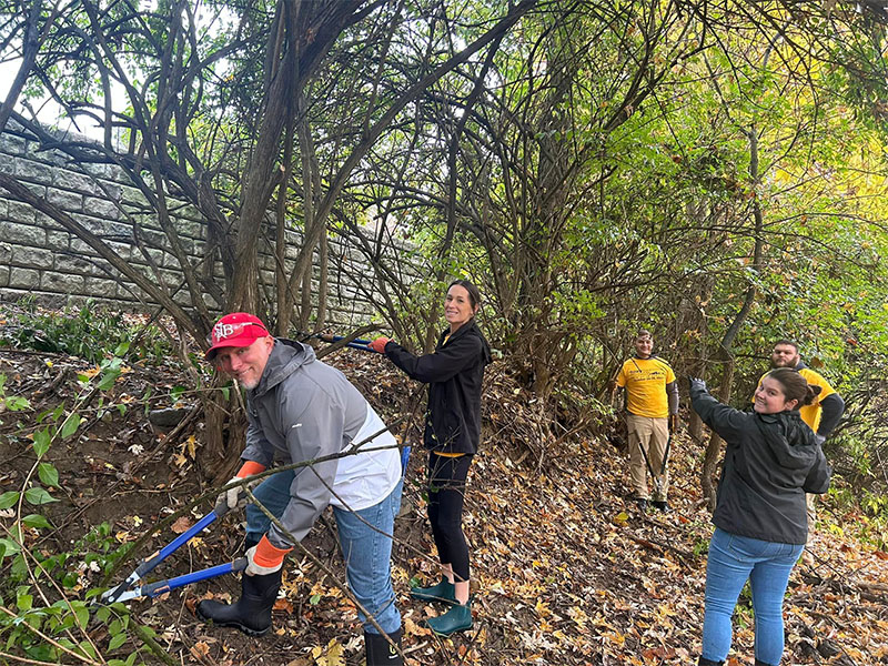 Community Involvement - Team Helping Trim Plant Growth